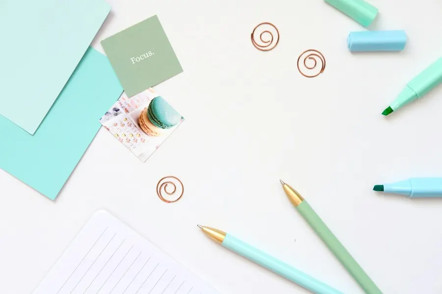 Stationery flat lay with pens, highlighters, notepads and paper clips